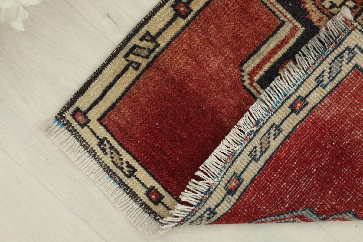 Folded corner of the rug, revealing the thickness of the wool pile and the cotton foundation.