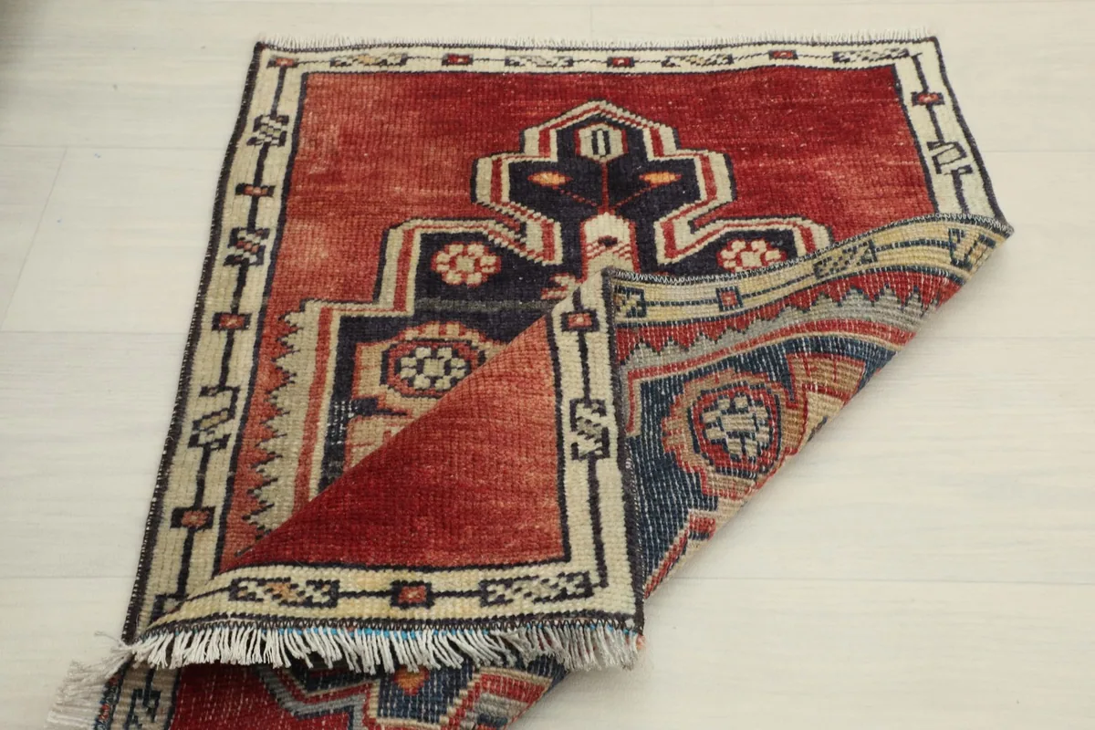 Another view of the rug with a section folded back, showing the back of the hand-knotted construction.