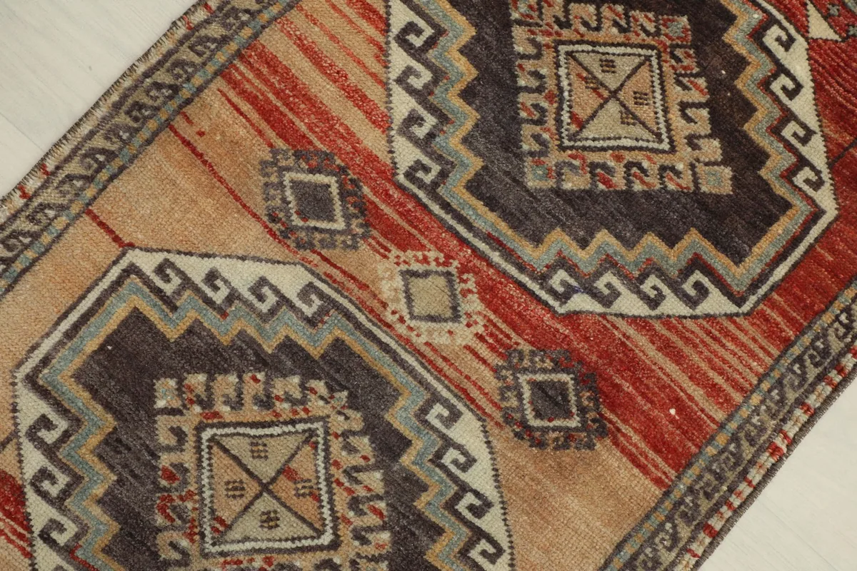 Detailed view of the rug's central design, showcasing the geometric motifs and color variations