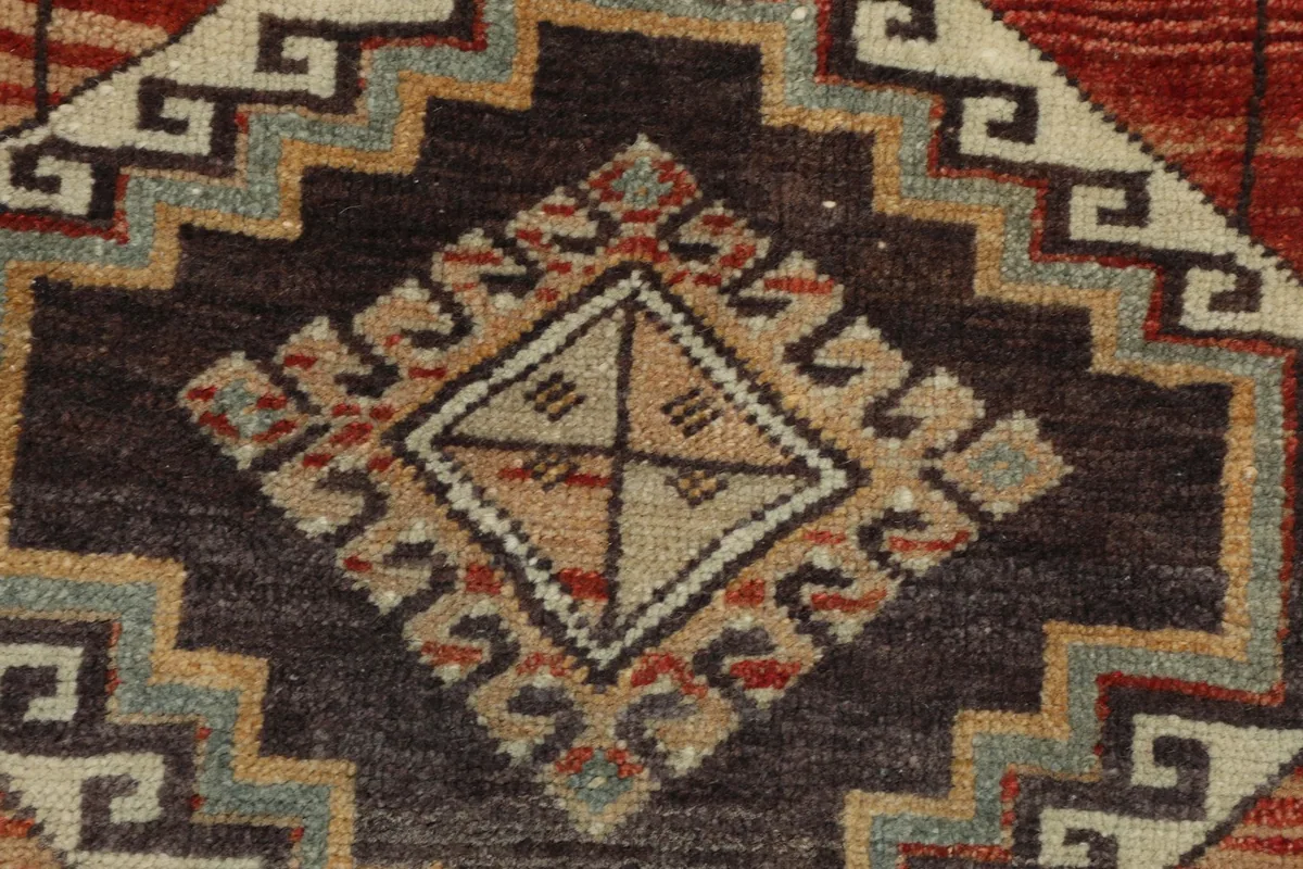 Close-up of a large brown geometric medallion with intricate patterns in gray and tan