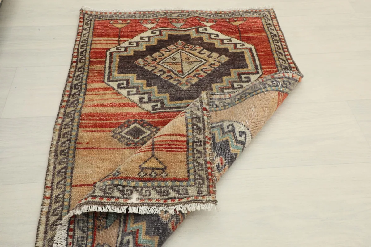 View of the rug with a corner folded, showing the thickness and the reverse side