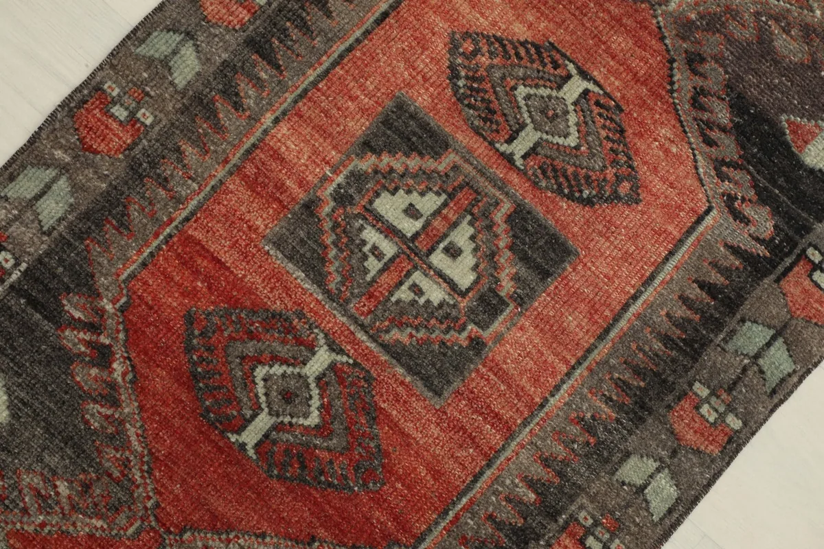 Overhead detail of the central red medallion and surrounding charcoal patterns
