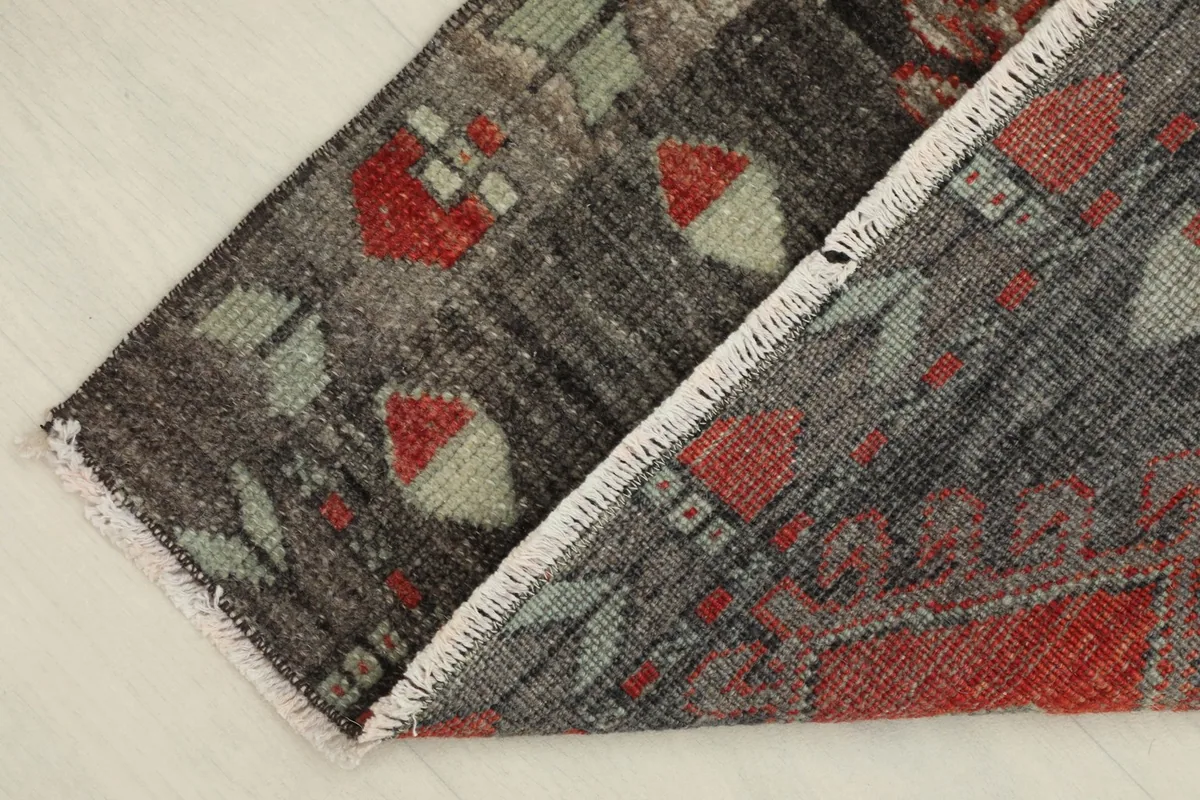Folded corner of the rug revealing the wool pile and cotton foundation