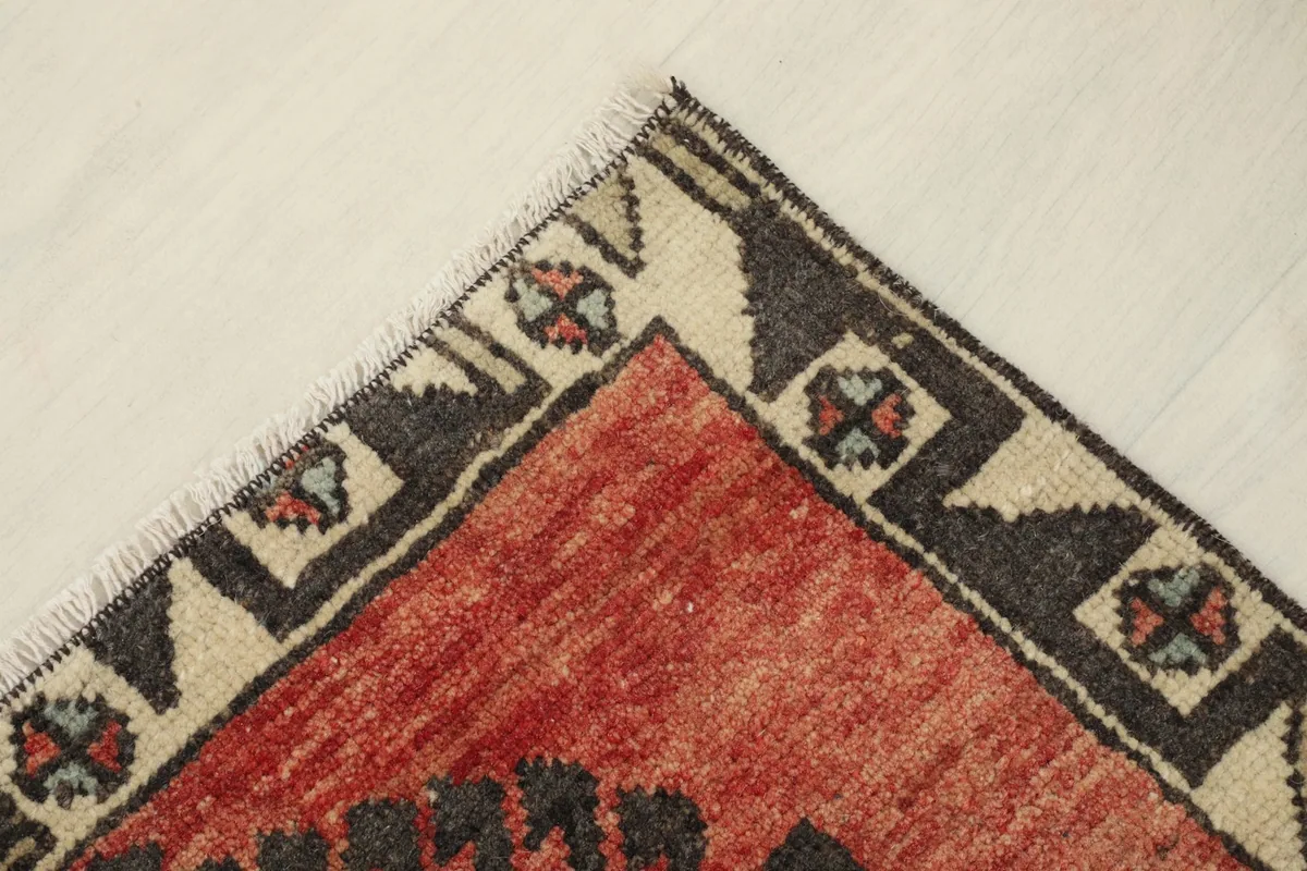 Opposite corner detail, highlighting the hand-knotted construction and border design