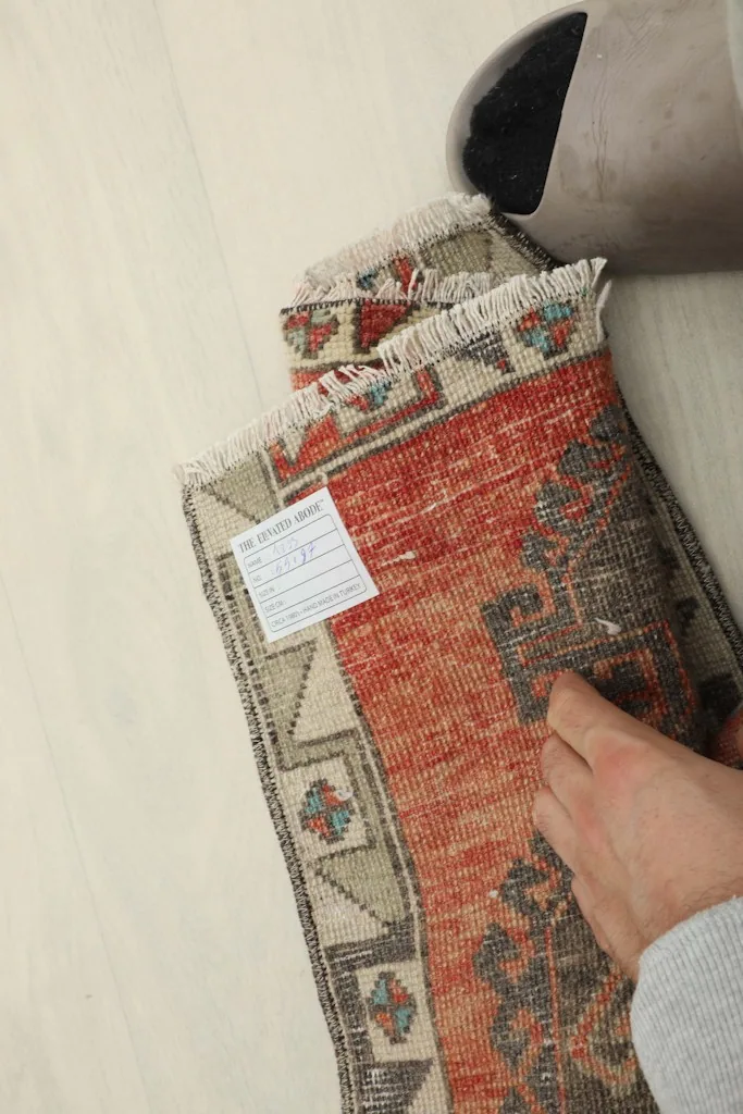 Back of the hand-knotted rug, displaying the cotton foundation and a product label