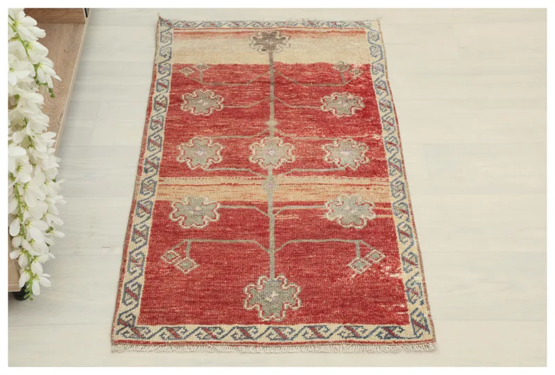 Full overhead view of the red tribal tree vintage Anatolian rug on a white background.