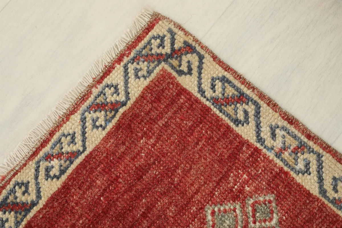Close-up of a corner, showing the intricate border pattern and the rug's slightly worn edge.
