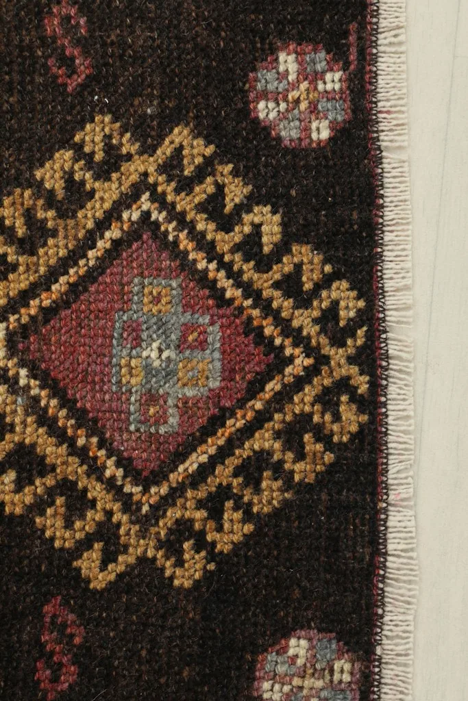 Close-up detail of the rug's corner, showing the hand-knotted wool pile and fringe.