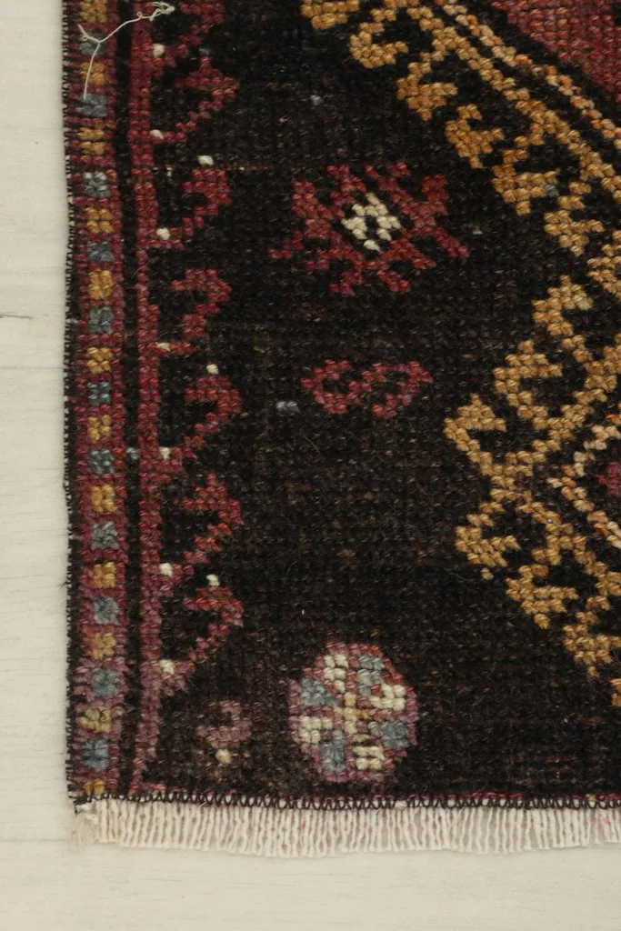Corner detail showing the subtle border design and the texture of the vintage wool pile.