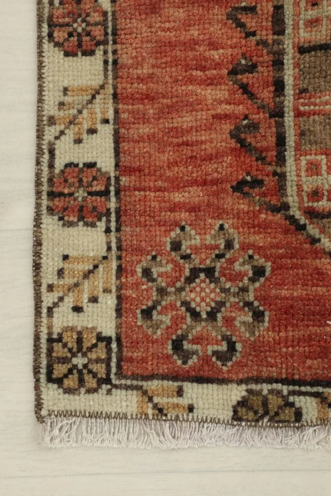 Detail of the beige border with floral-inspired motifs and the rust field