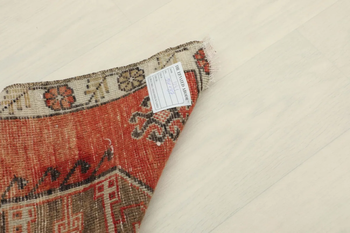 View of the back of the rug with a label, showing the hand-knotted construction