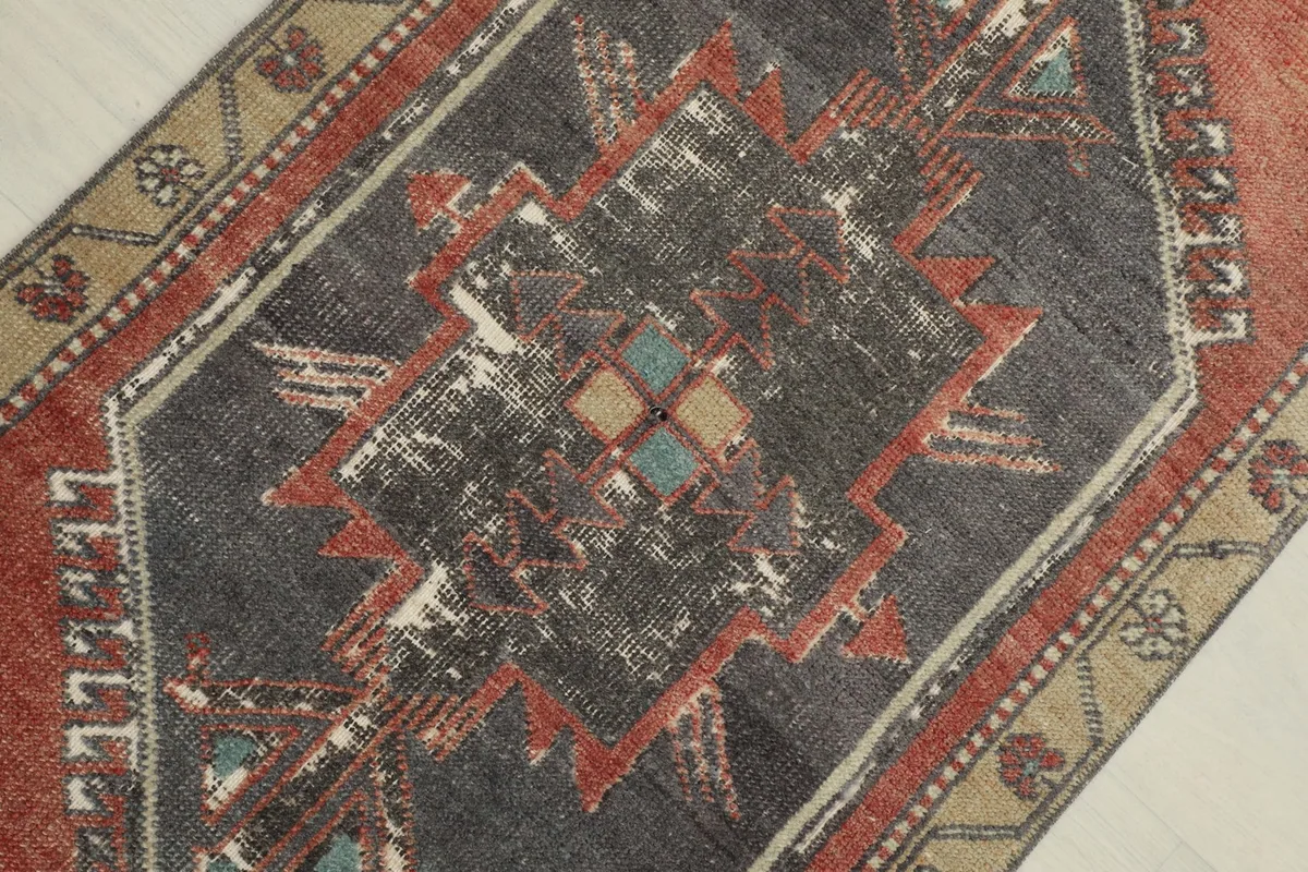 Detail view of the central charcoal geometric medallion with its intricate patterns and color variations.