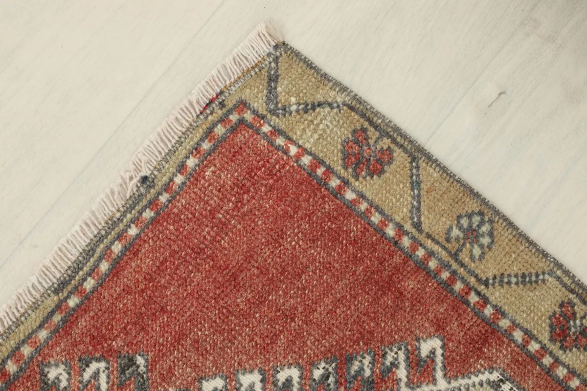 Another corner view, emphasizing the blend of red and tan in the border and the short fringe.