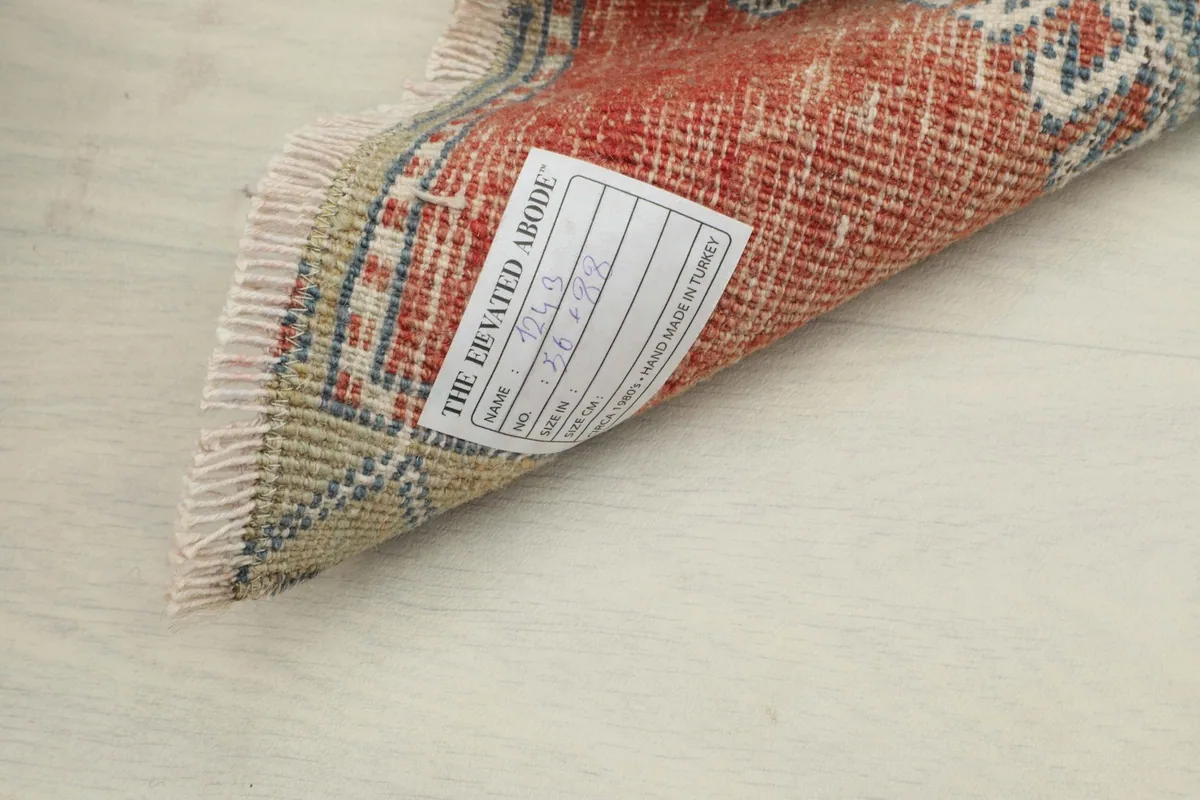View of the back of the rug with a label, showcasing the hand-knotted texture and foundation.