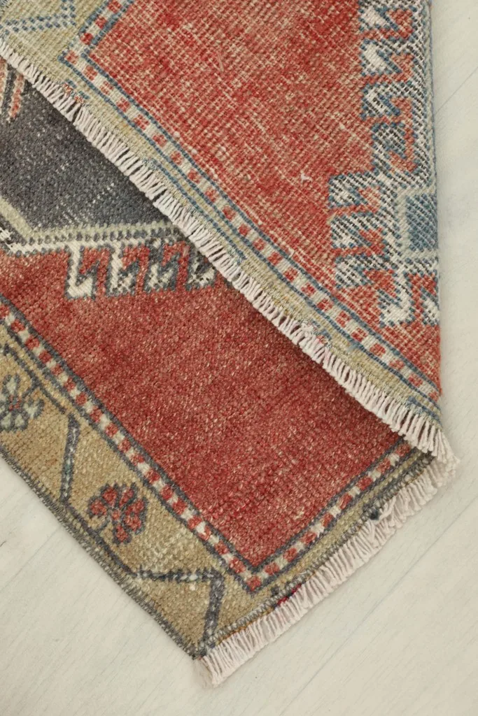 Rug partially folded, revealing the reverse side and the hand-knotted cotton foundation.