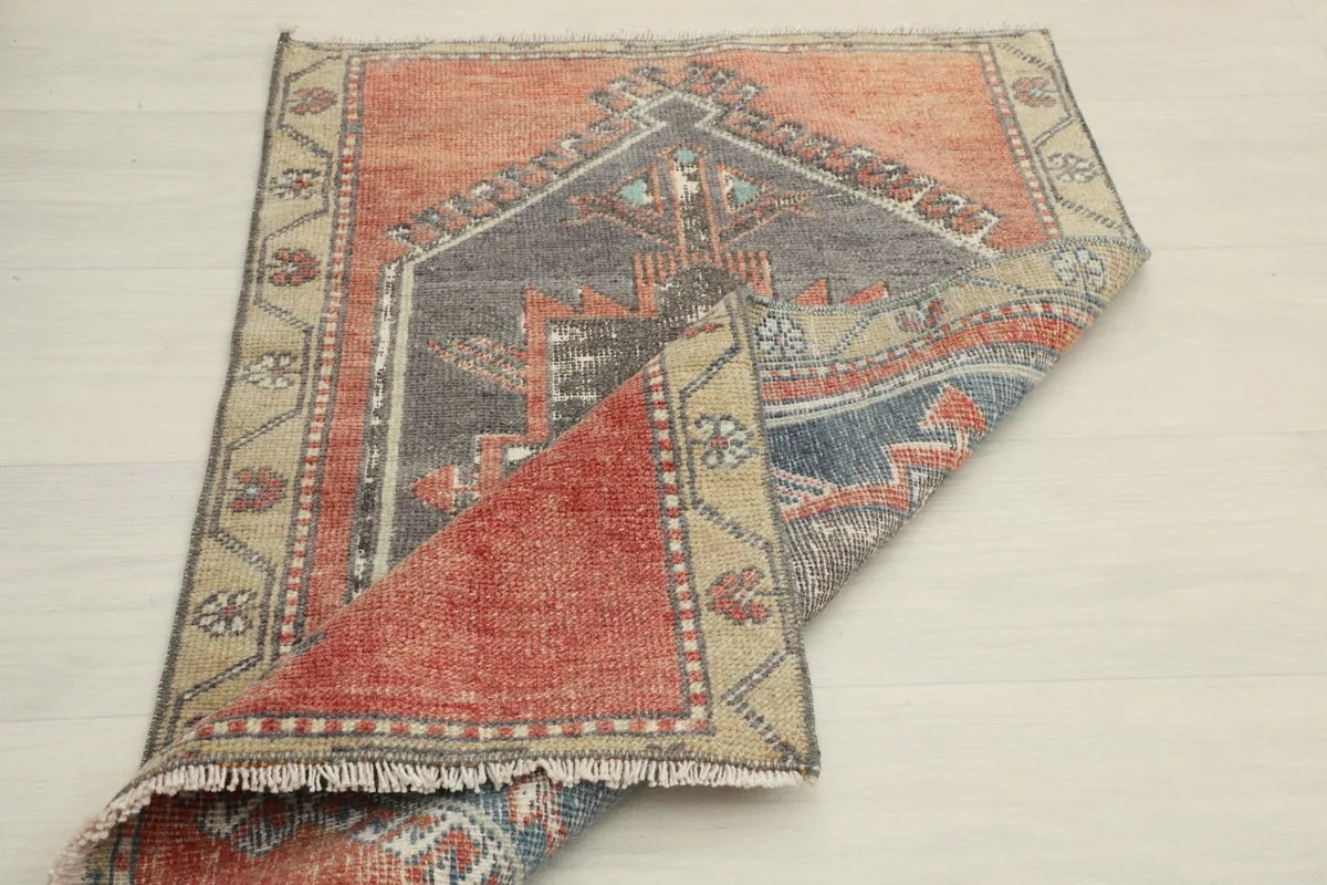 The rug folded over itself, showing the thickness of the wool pile and the construction.