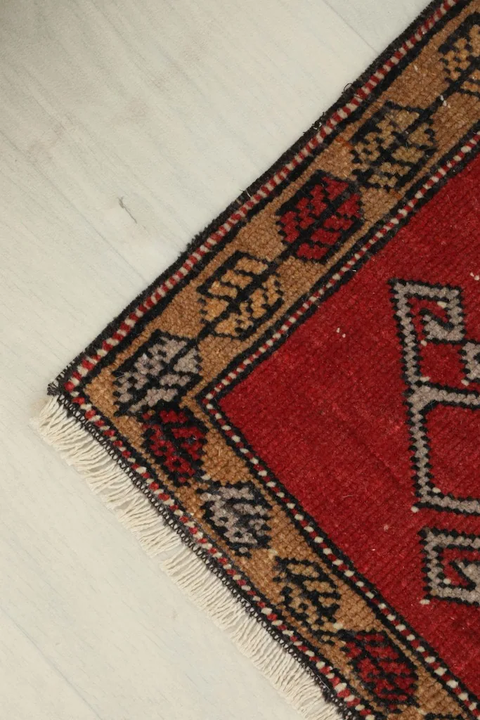 Angled view highlighting the corner and edge of the rug, showing slight wear.