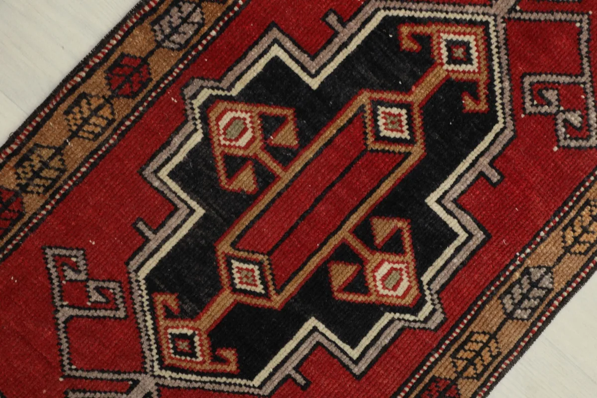 Close-up view of the central black and red geometric medallion-like design.