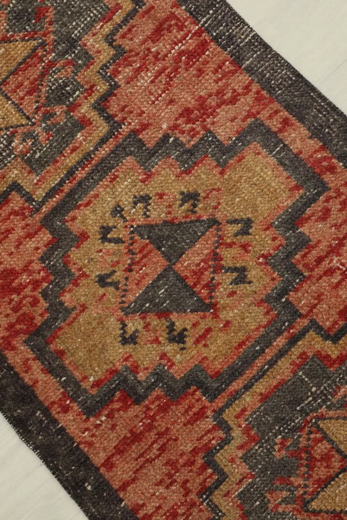 Diagonal close-up showing the central tribal pattern and texture of the red doormat