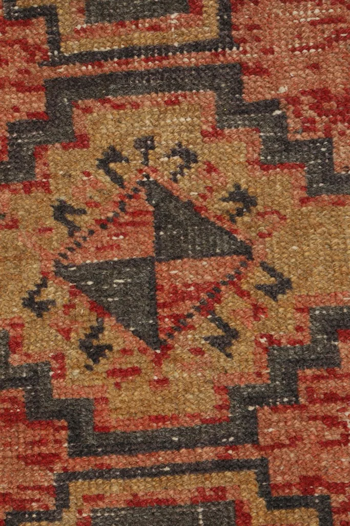 Detailed view of the hand-knotted wool pile and intricate geometric design