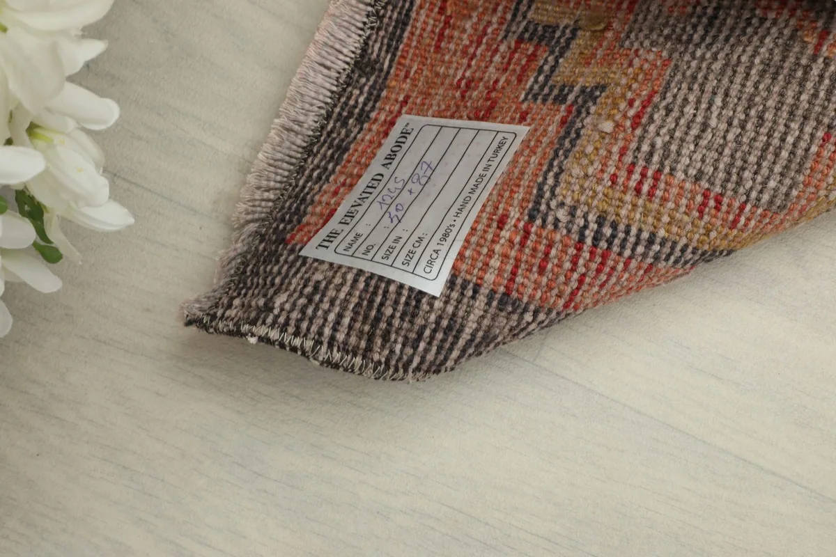 Close-up of the rug's back, displaying the hand-knotted cotton foundation and product label