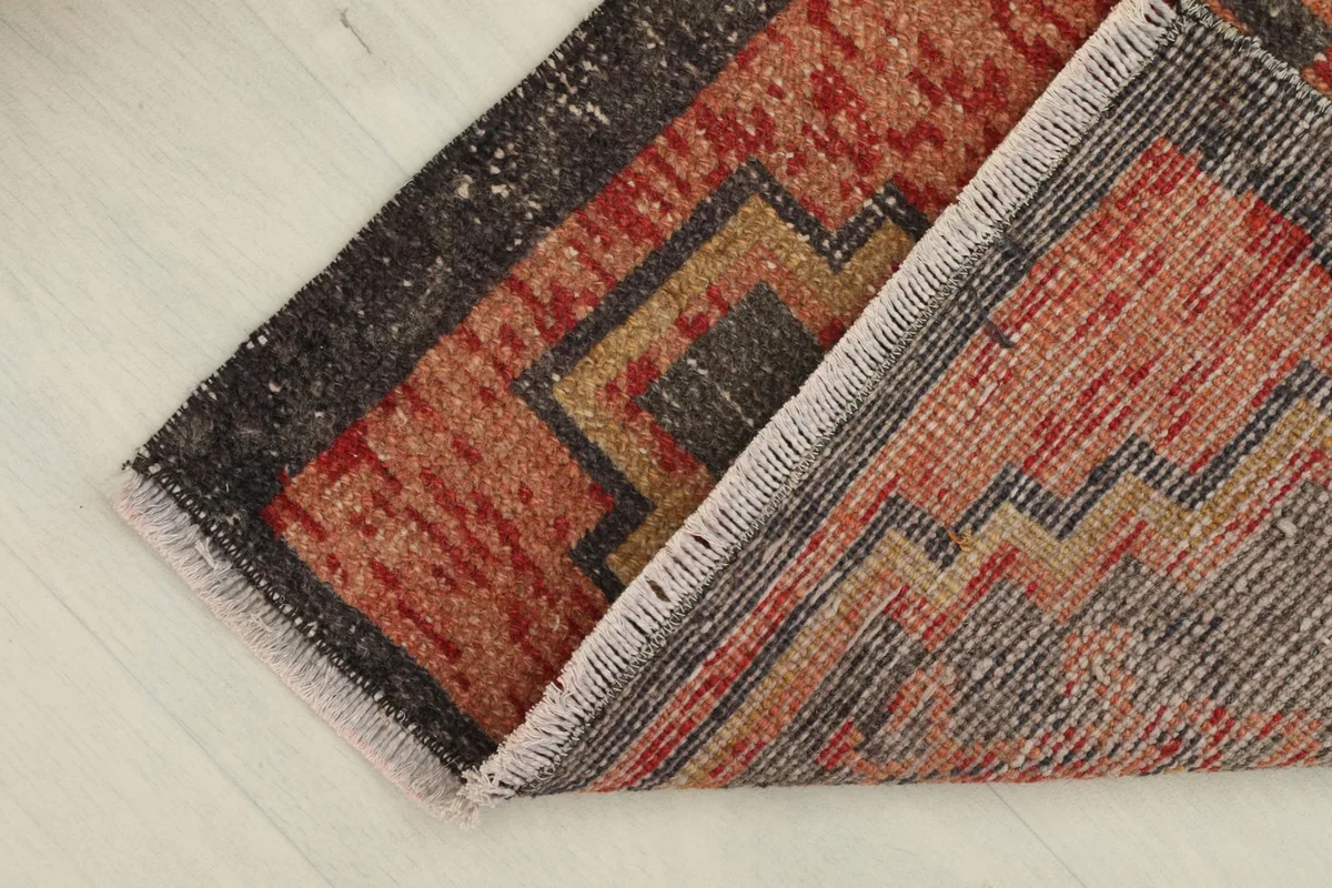 The rug partially folded to show the flexibility and thickness of the wool pile