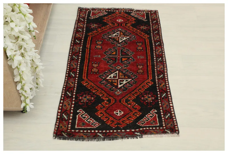Full top view of the 1'10" x 3'5" vintage Anatolian rug on a white floor