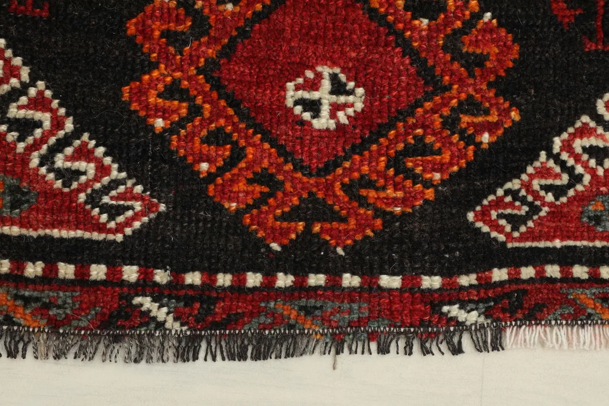 Close-up detail of the hand-knotted wool pile and fringe on the rug's edge