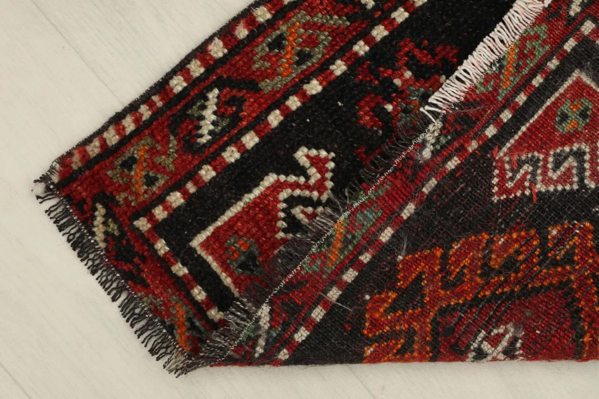 View of the rug folded, showing the flexibility and thickness of the wool pile