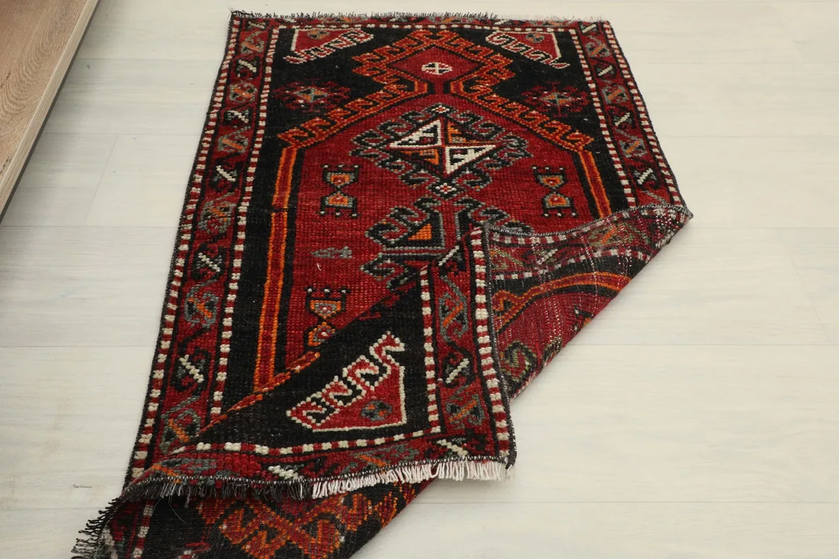 The rug partially folded, displaying its full design and the softness of the wool