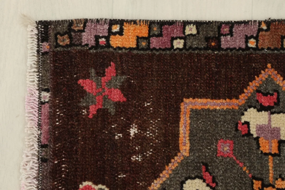 Close-up of the upper left corner, showing the colorful geometric border design and fringe.