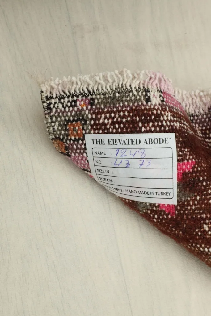 View of the back of the rug with a label, indicating its hand-knotted origin and material.