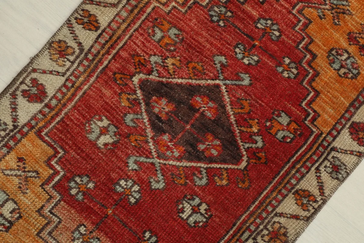 Close-up detail of the central red area with a brown geometric motif