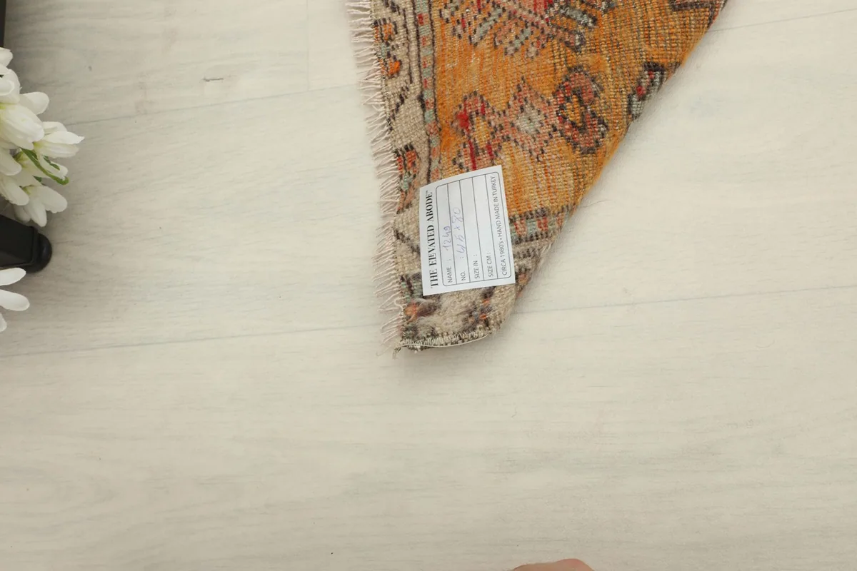 Backside of the rug, showing the hand-knotted cotton foundation and a label