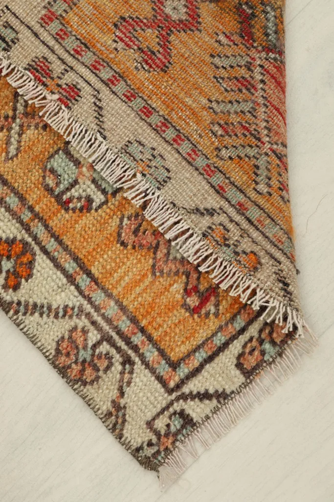 Rug corner folded to show the thickness and back of the hand-knotted wool pile