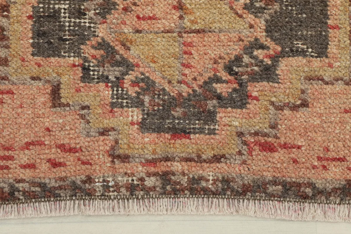 Close-up of the rug's center, highlighting the charcoal and tan geometric motifs and wool texture.