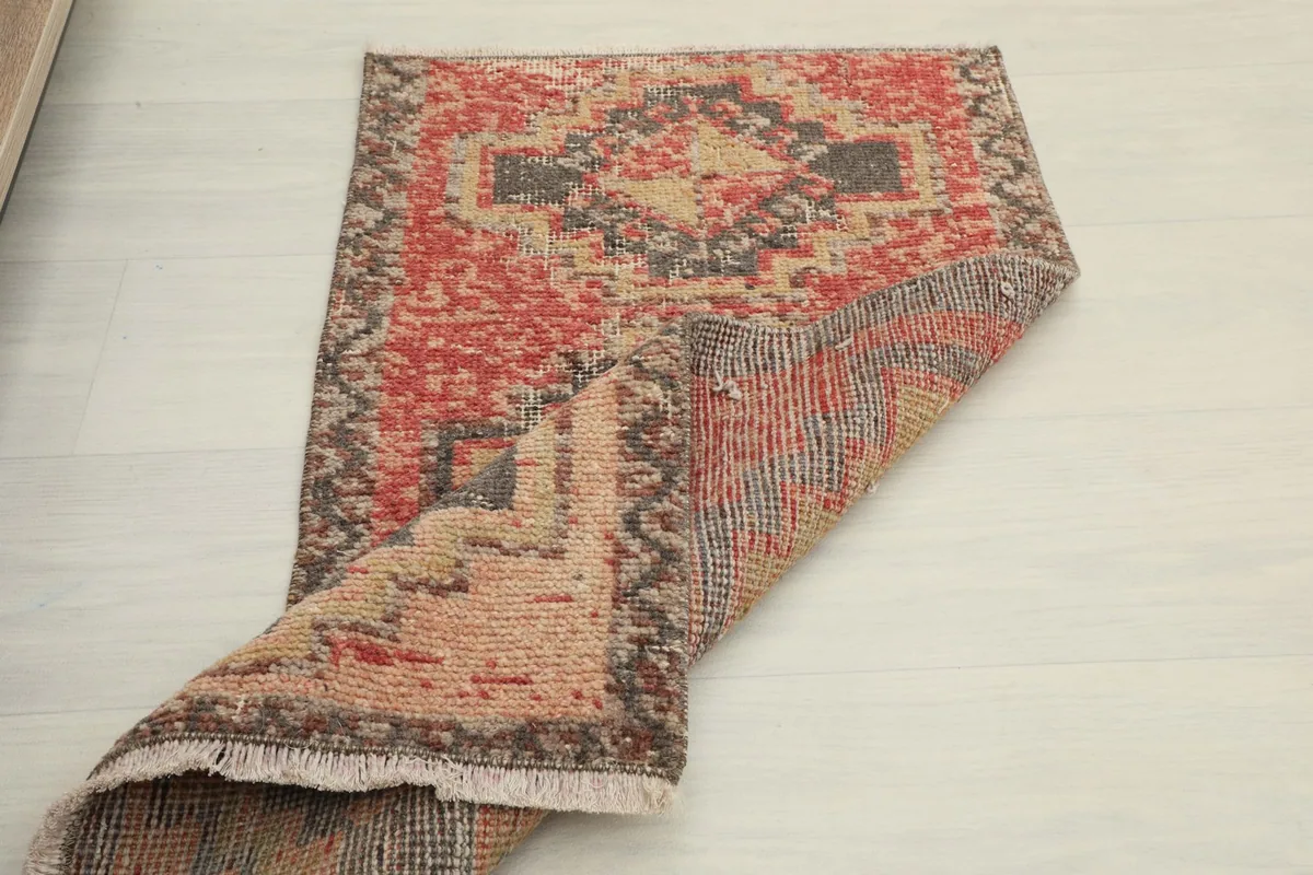 Overhead view of the rug with one corner folded back, showing both the pile and the woven foundation.