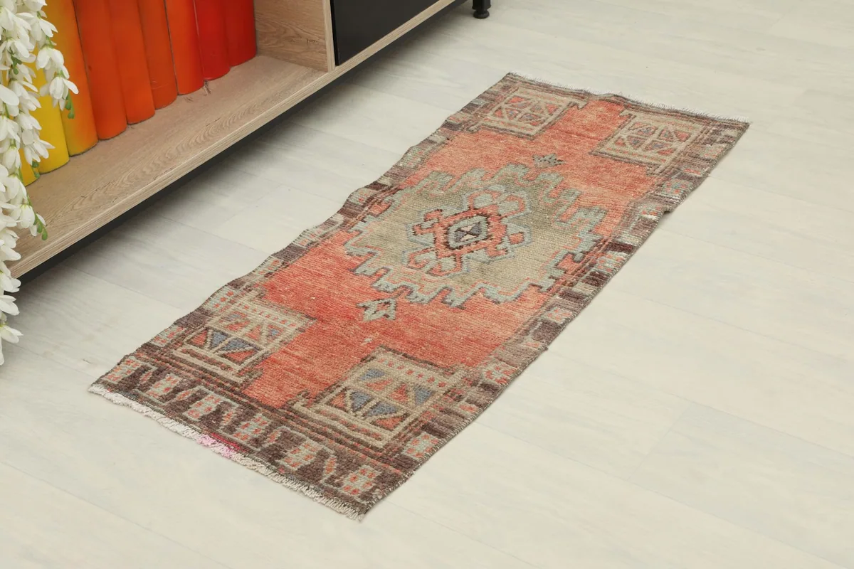 Angled view of the vintage rust doormat, showing its full length and geometric design.