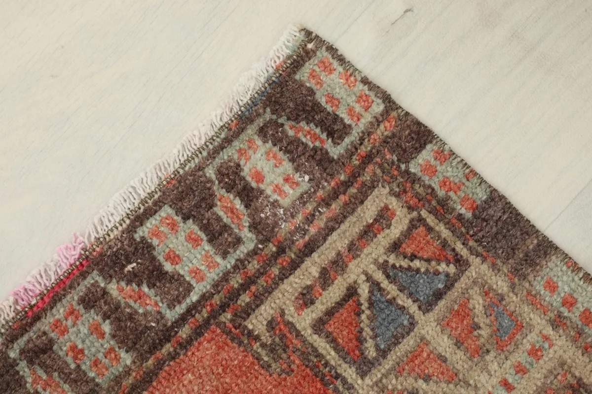 Corner detail of the rug's pattern and fringe, highlighting the hand-knotted texture.