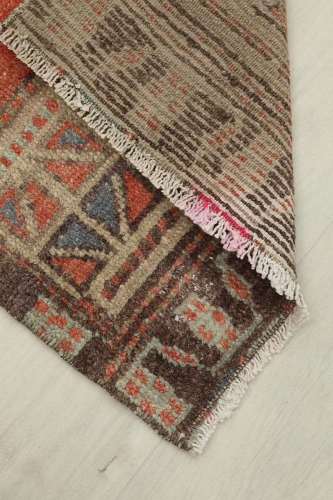 View of the rug's underside and fringe, showing the cotton foundation and hand-knotting.