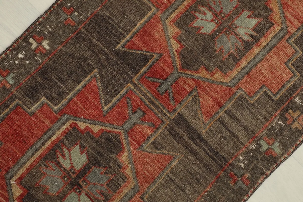 Dynamic angled view of the rug's central design, emphasizing the layered geometric shapes in orange and brown.