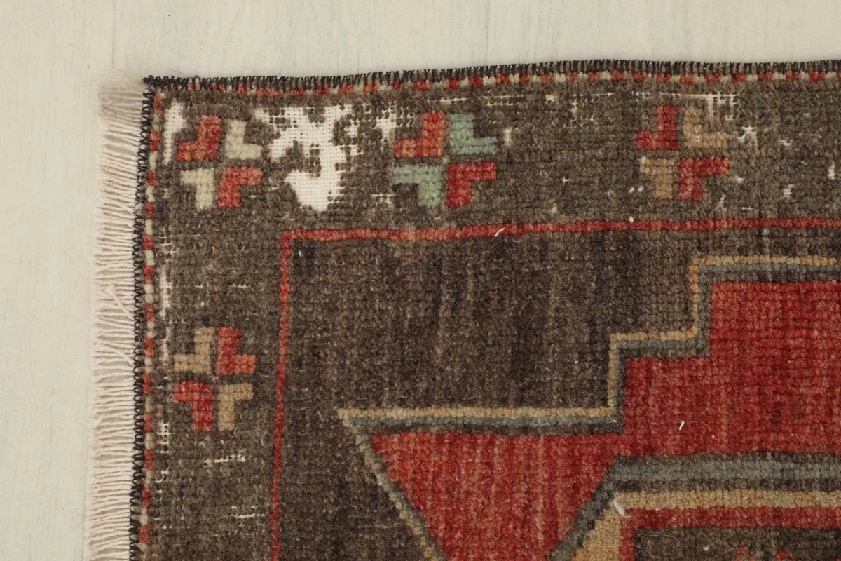 Edge detail of the rug, revealing the wear and patina along the border and the subtle color variations.