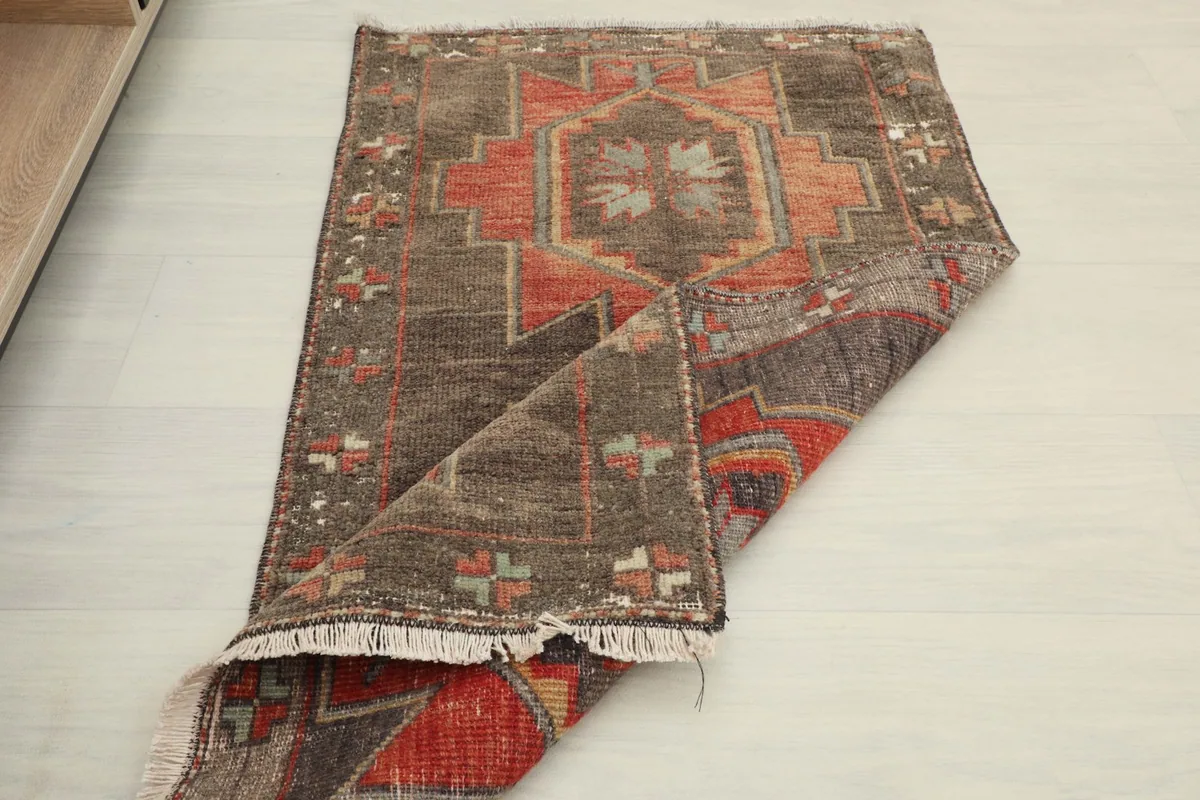 Partially folded rug on a light floor, illustrating its flexibility and the overall design from a different perspective.