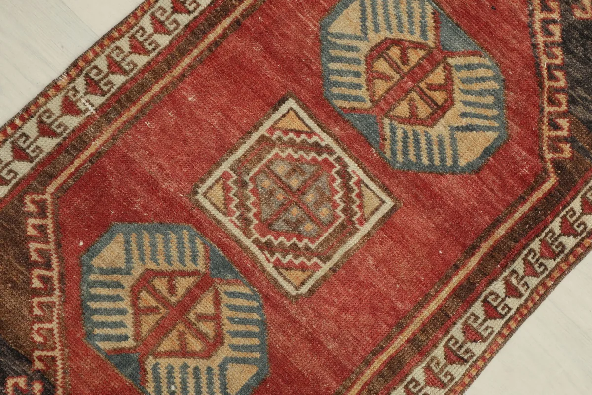 Close-up of the central red field showcasing blue, tan, and red geometric motifs.