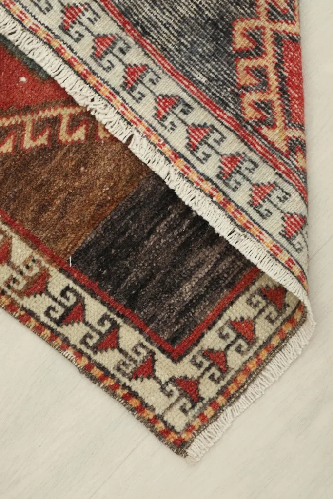 View of the rug's underside, showing the cotton foundation and hand-knotted construction.