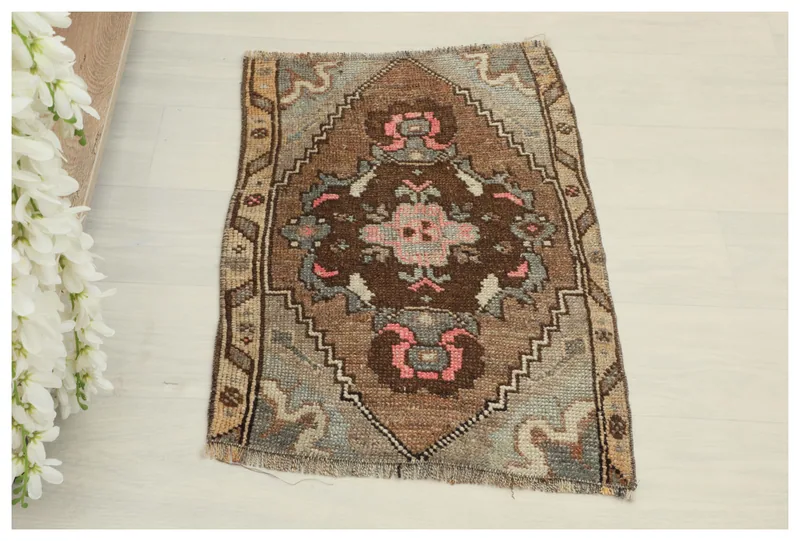Full top view of the 1'7" x 2'4" brown, pink, and blue vintage Anatolian wool rug on a white background.