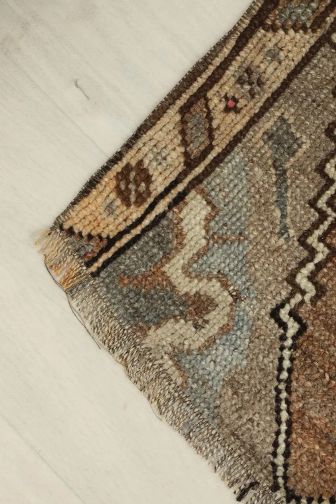 Angled detail of a corner, showing the wool pile texture and the blend of blue, beige, and brown colors.