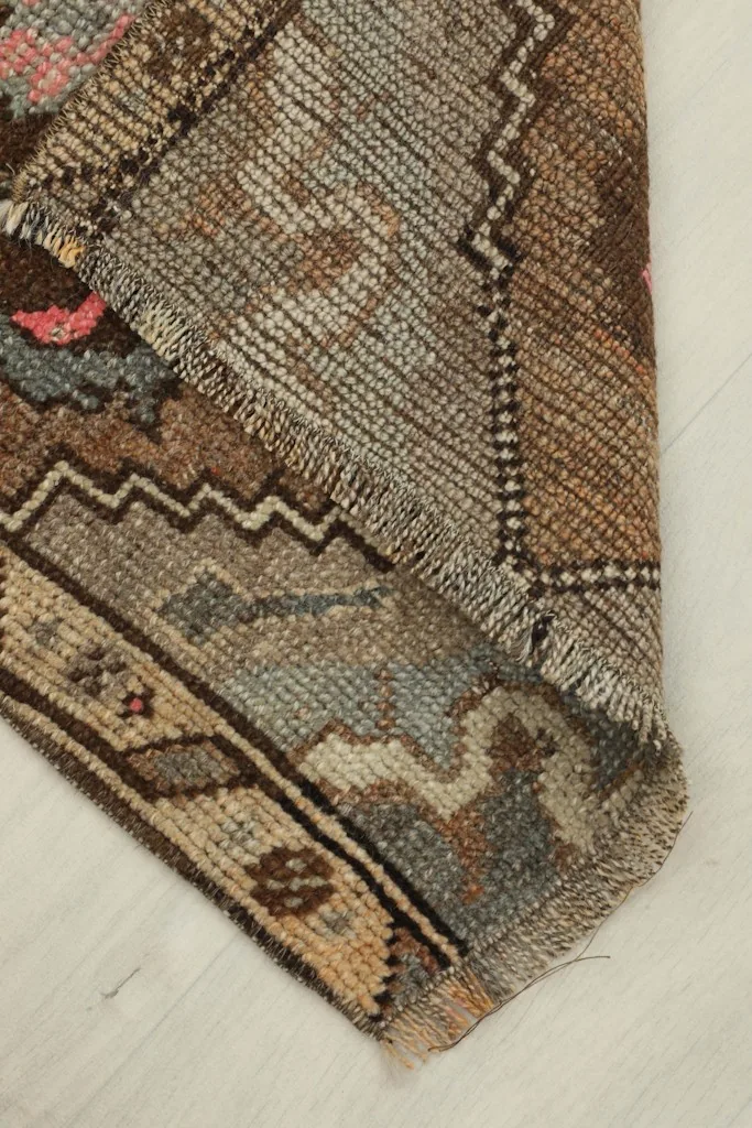View of the rug folded to reveal the cotton foundation and the reverse side of the hand-knotted construction.