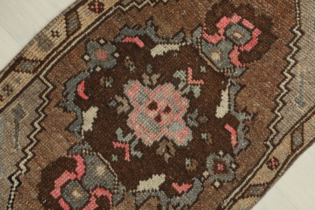 Overhead close-up capturing the central medallion-like design with pink and blue floral elements.