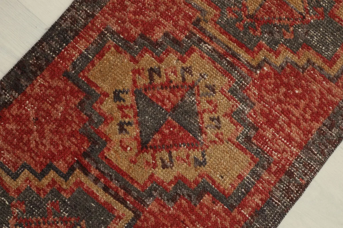 Detailed view of the central geometric motif on the red field, showing knotting and texture.